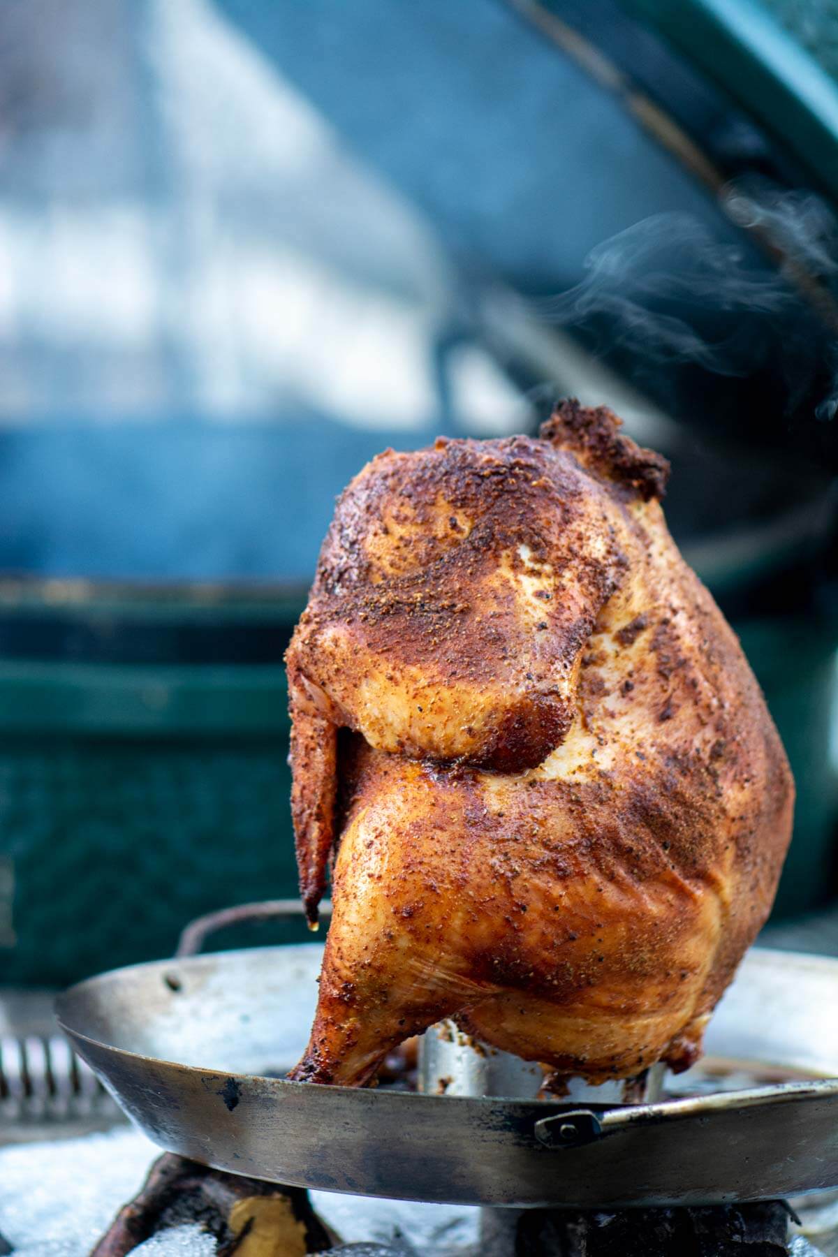 Grilled Chicken on the beer can holder in front of the Big Green Egg.