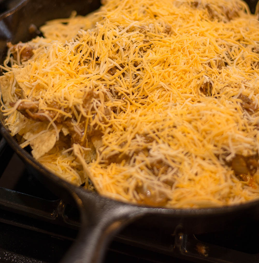 Pulled Pork Nachos Layered in Cast Iron Skillet and Ready for the Oven
