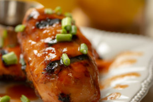 Reserved Sweet and Spicy BBQ Sauce poured over the Grilled Chicken Breasts