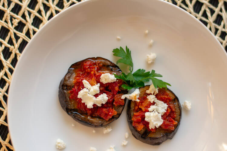 Two delicious small rounds of Grilled Eggplant, Bruschetta and Goat Cheese