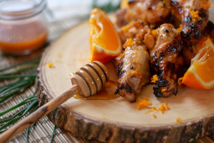 Grilled Orange and Honey Sriracha Chicken wings on a serving tray.