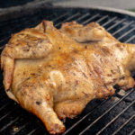 thirty minutes later, turn the chicken over and grill the opposite side. This is an image of the big green egg with indirect heat and the chicken roasting