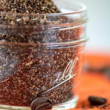 jar of java rub with whole coffee beans scattered on an orange napkin.