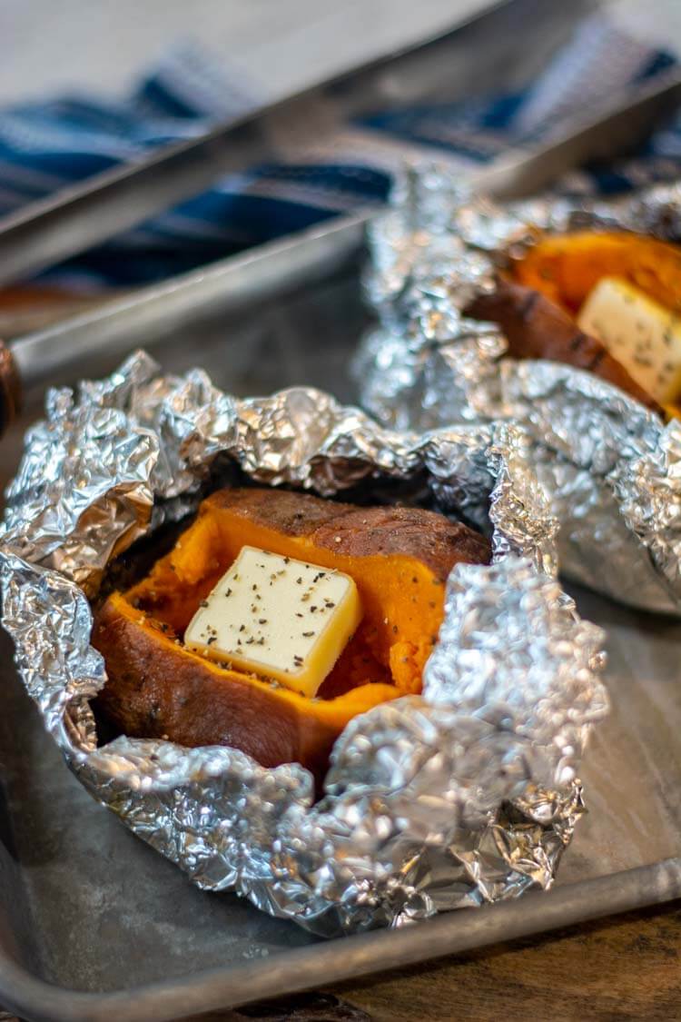 After grilling, the opened foil packets reveal a perfectly grilled baked sweet potato. Added here is some butter.
