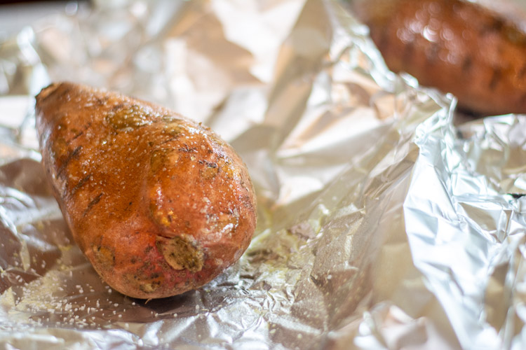 salted and oiled sweet potato in foil ready to be wrapped and grilled