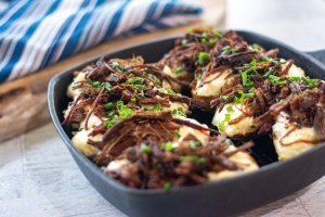 brisket twice baked potatoes in the cast iron skillet and topped with fresh chives
