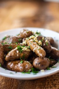 white bowl with a full side dish of smoked potatoes. The garlic, parsley and melted butter are decadent