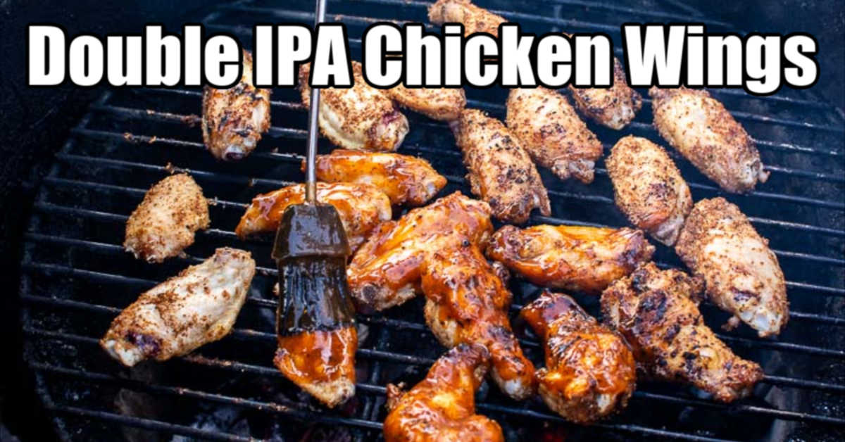 brushing chicken wings with a homemade IPA BBQ sauce over hot coals in the grill