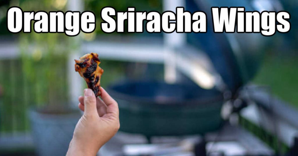 holding up an orange sriracha chicken wing in front of the grill