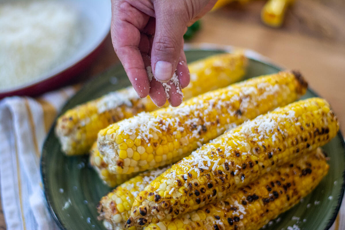 sprinkling on aged Cotija cheese on the beer corn