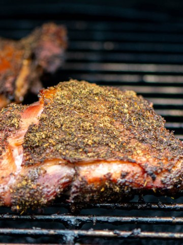 smoked thigh on the grill covered in poultry seasoning