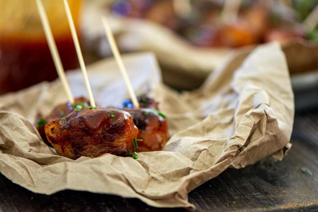 cooked meatball on butcher paper with citrus BBQ sauce