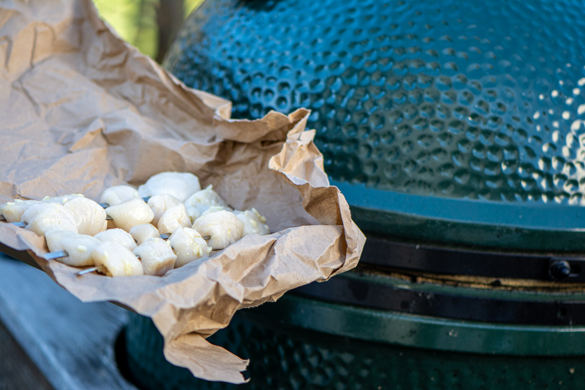 scallops on a butcher paper lined sheet pan in front of the Big Green Egg.