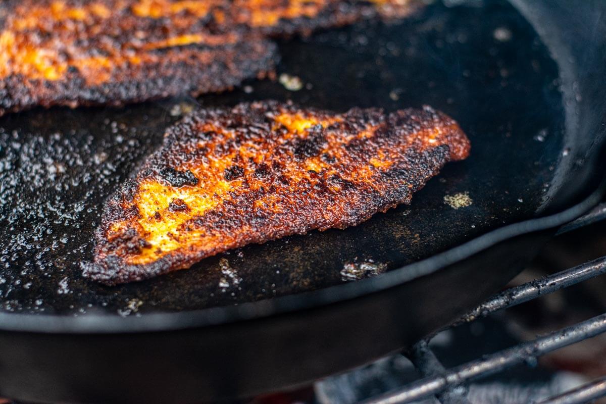 blackened sole fillet on the cast iron skillet ready to be removed.