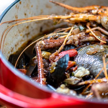 Seafood stew in a dutch oven loaded with fresh seafood.