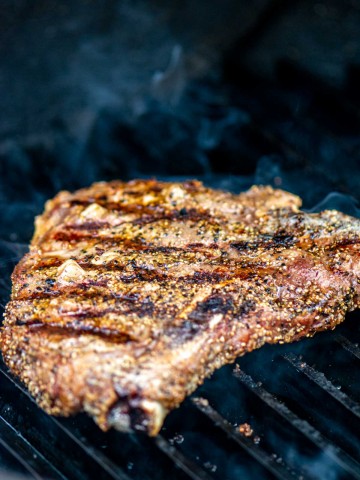 t bone steak on a grillgrate with gorgeous sear marks.