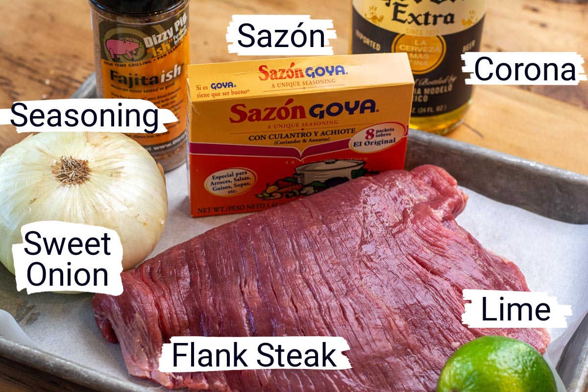 ingredients for the flank steak marinade on a sheet pan with labels.