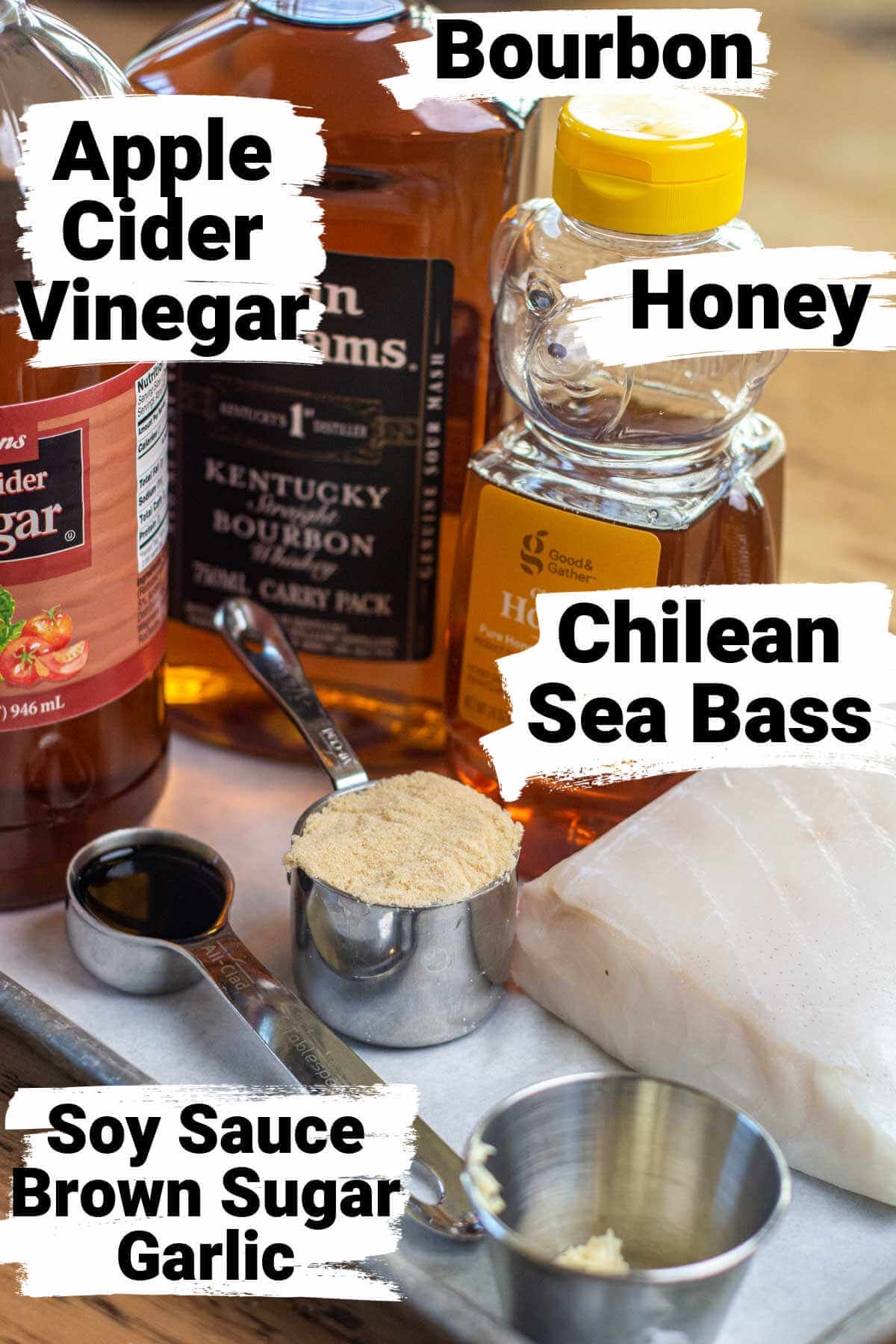 ingredients on a lined sheet pan for the sea bass and the bourbon glaze, all with labels.