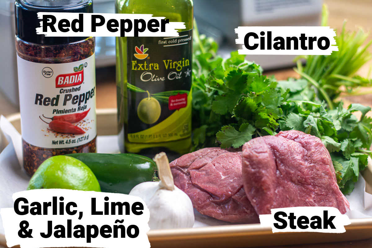 ingredient photo showing steak, cilantro, lime, garlic, jalapeño and red pepper flakes with labels.