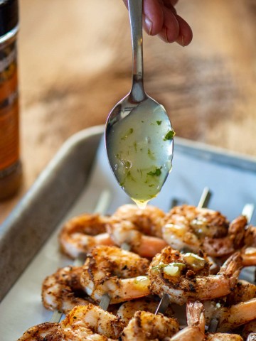 dripping a tequila lime sauce on to the salt black shrimp.