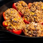 skillet on the grill filled with stuffed peppers with mexican seasoning.