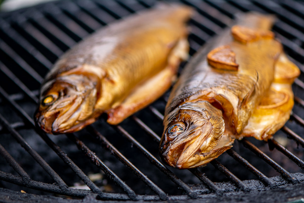two trout on the grill with lemons and butter.