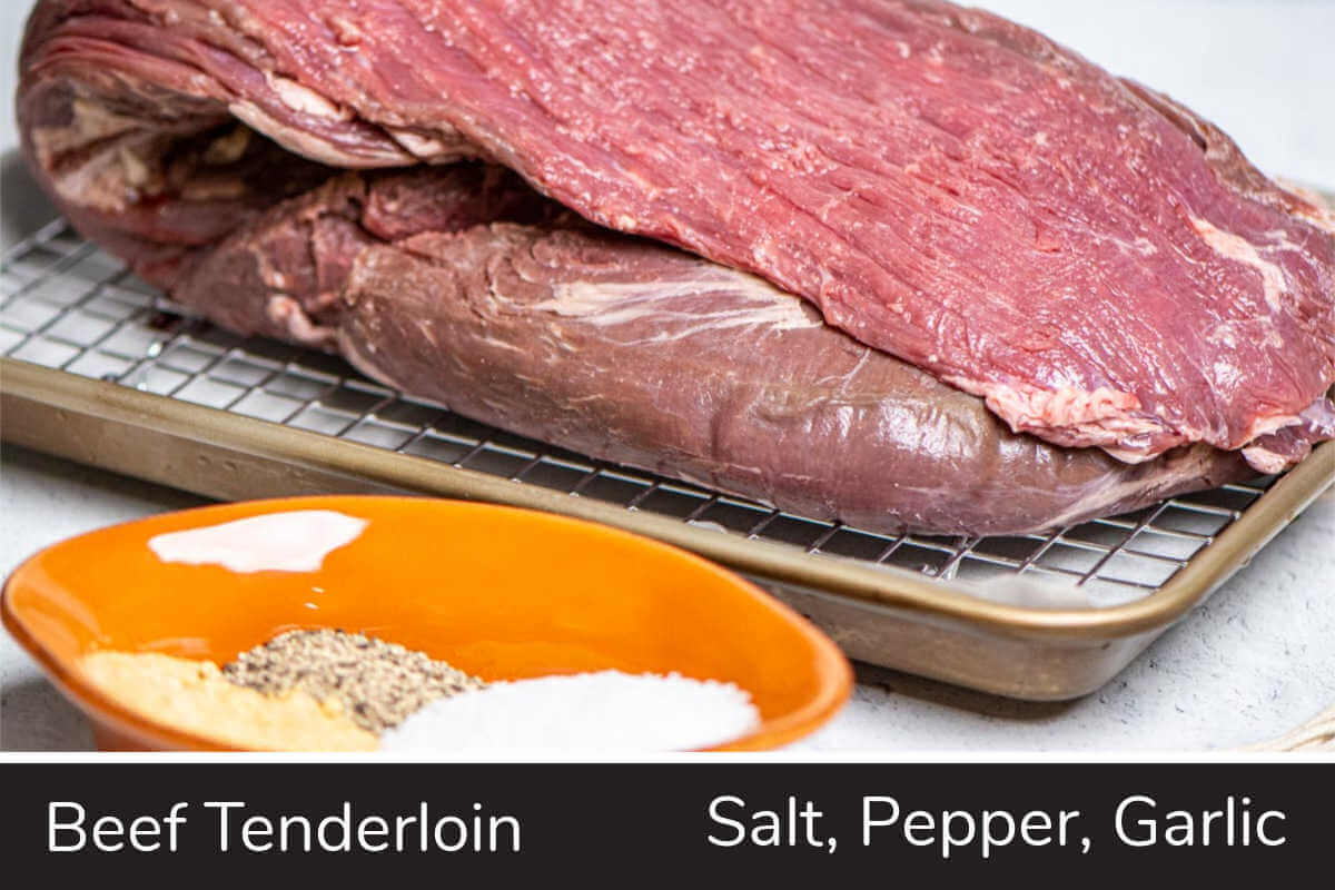 ingredient photo showing the tenderloin on a sheet pan and a container with salt, pepper and garlic.