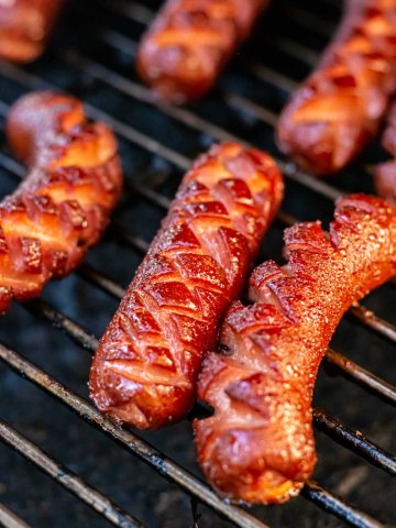 slotted hot dogs on the grill after having been lightly smoked.