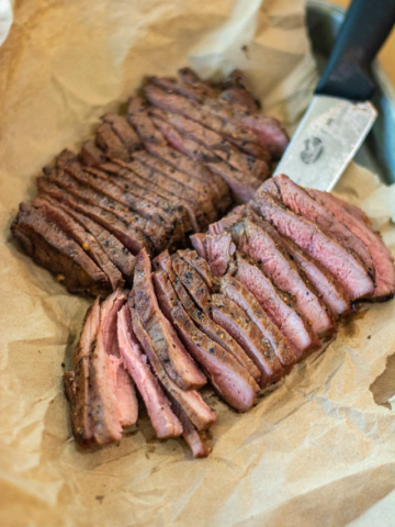 Image of grilled and sliced ranch steaks on butcher's paper.