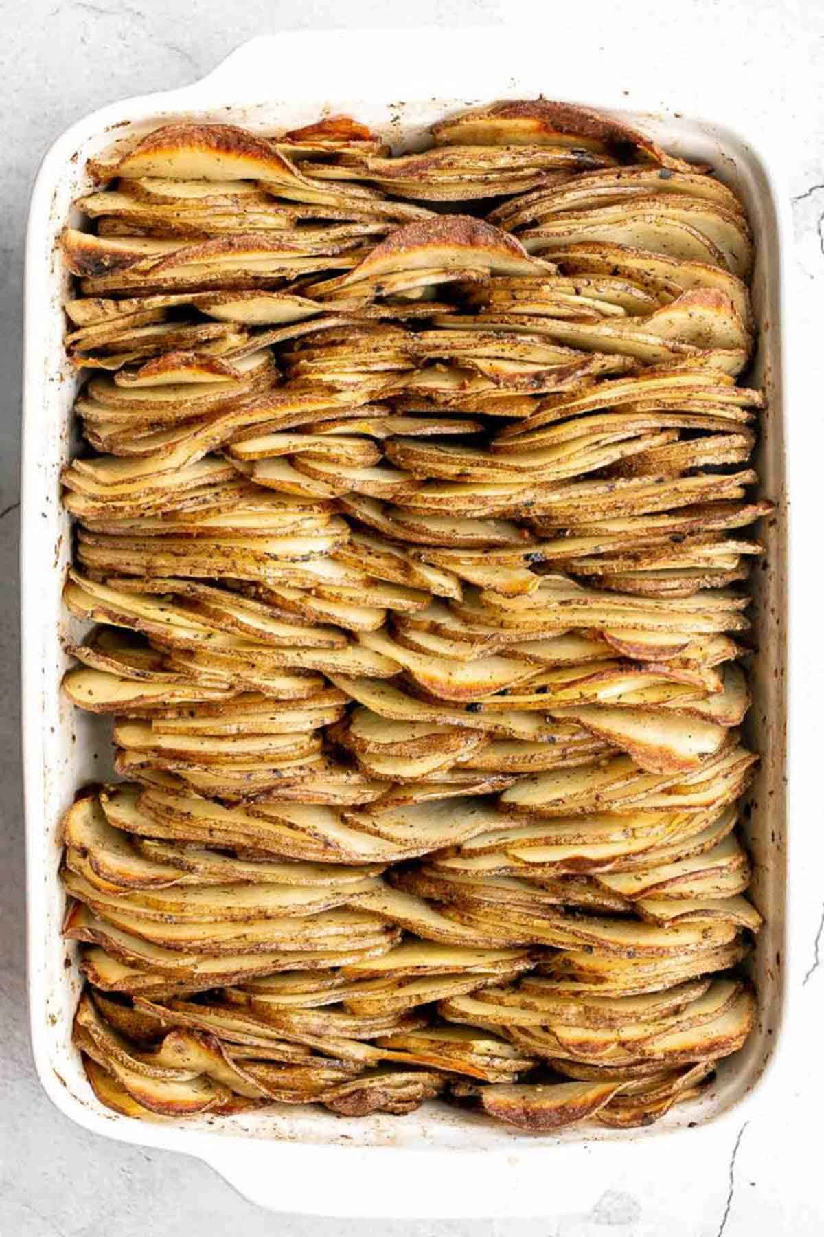 tight layers of thinly sliced potatoes in a baking dish.