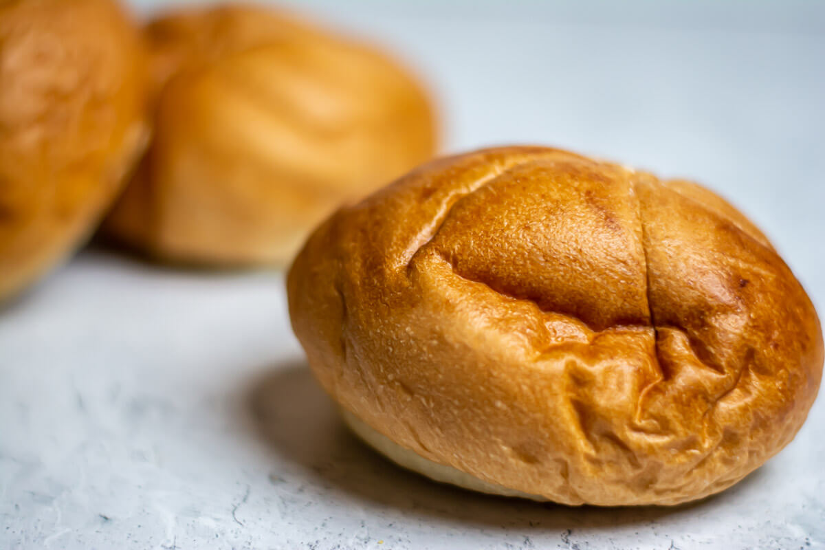 simple stack of kaiser rolls on a white counter.