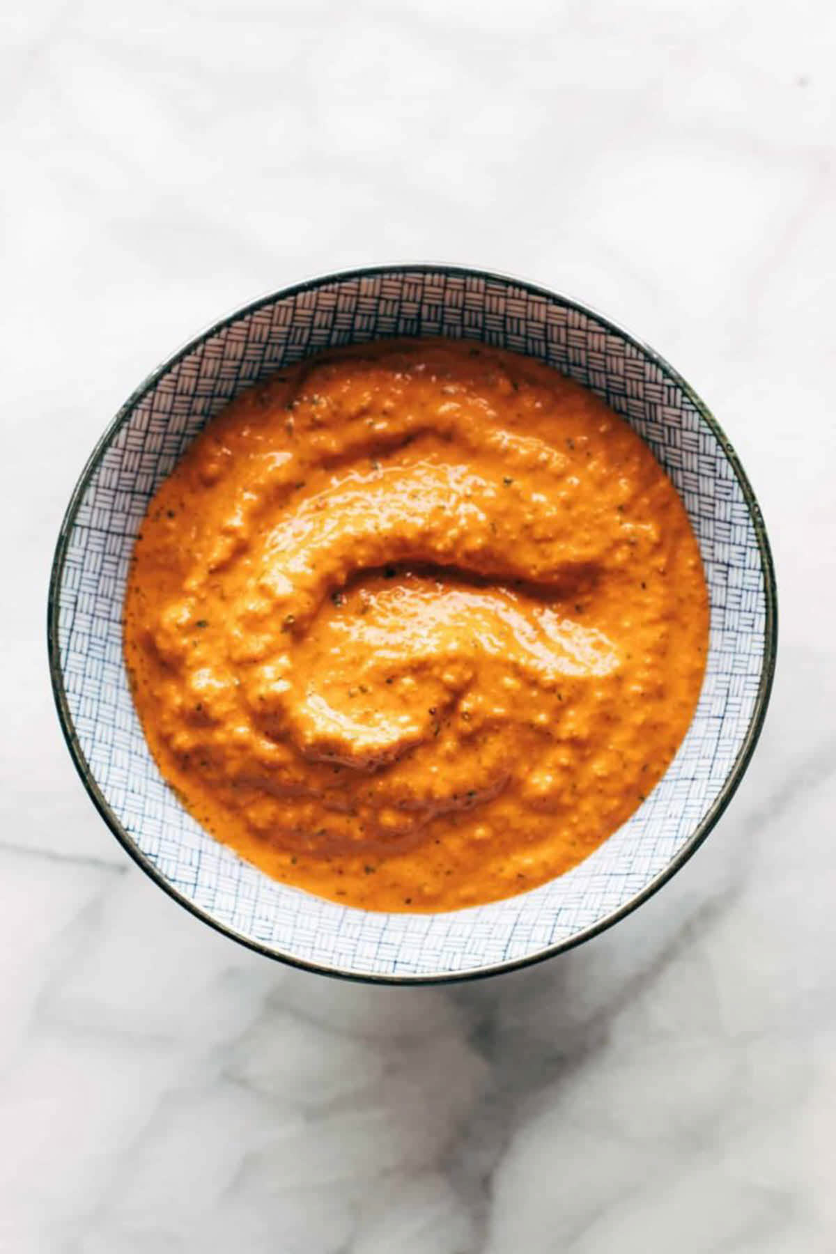 top down view of roasted red pepper sauce in a decorative bowl.