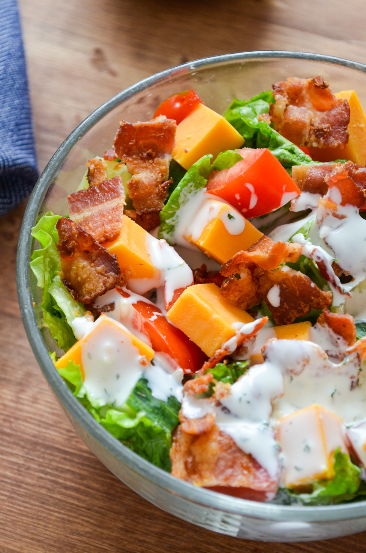 salad with chunks of tomatoes, bacon, cheese and lettuce with a creamy dressing.
