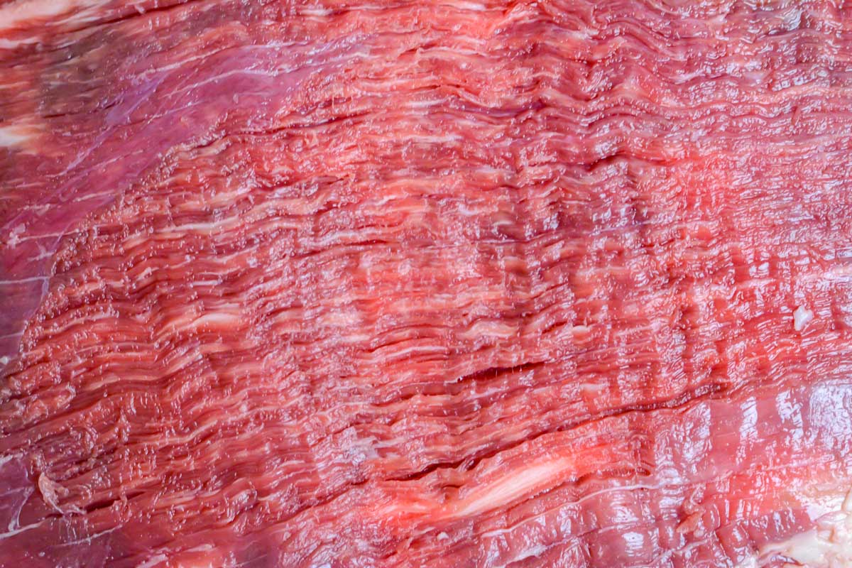 top down view of the raw flank steak to show how defined the grain of the meat is.