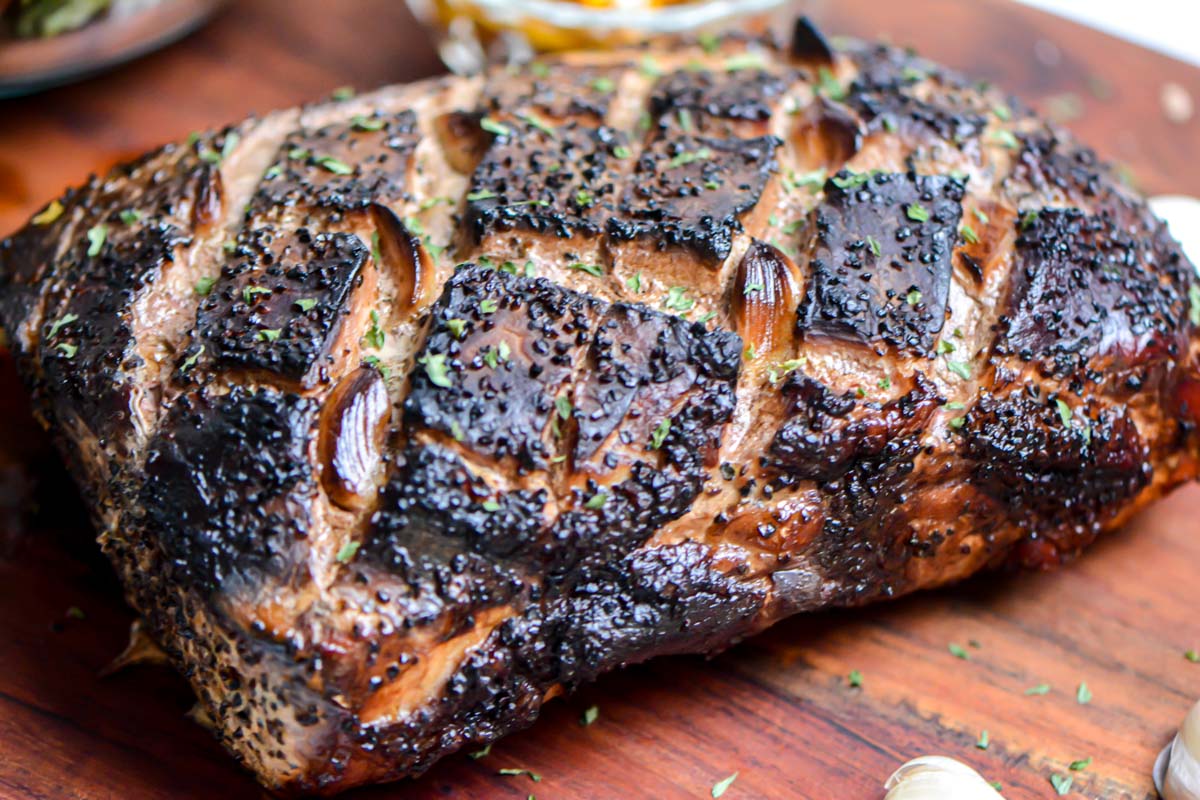 rich and dark smoked pork roast on a cutting board.
