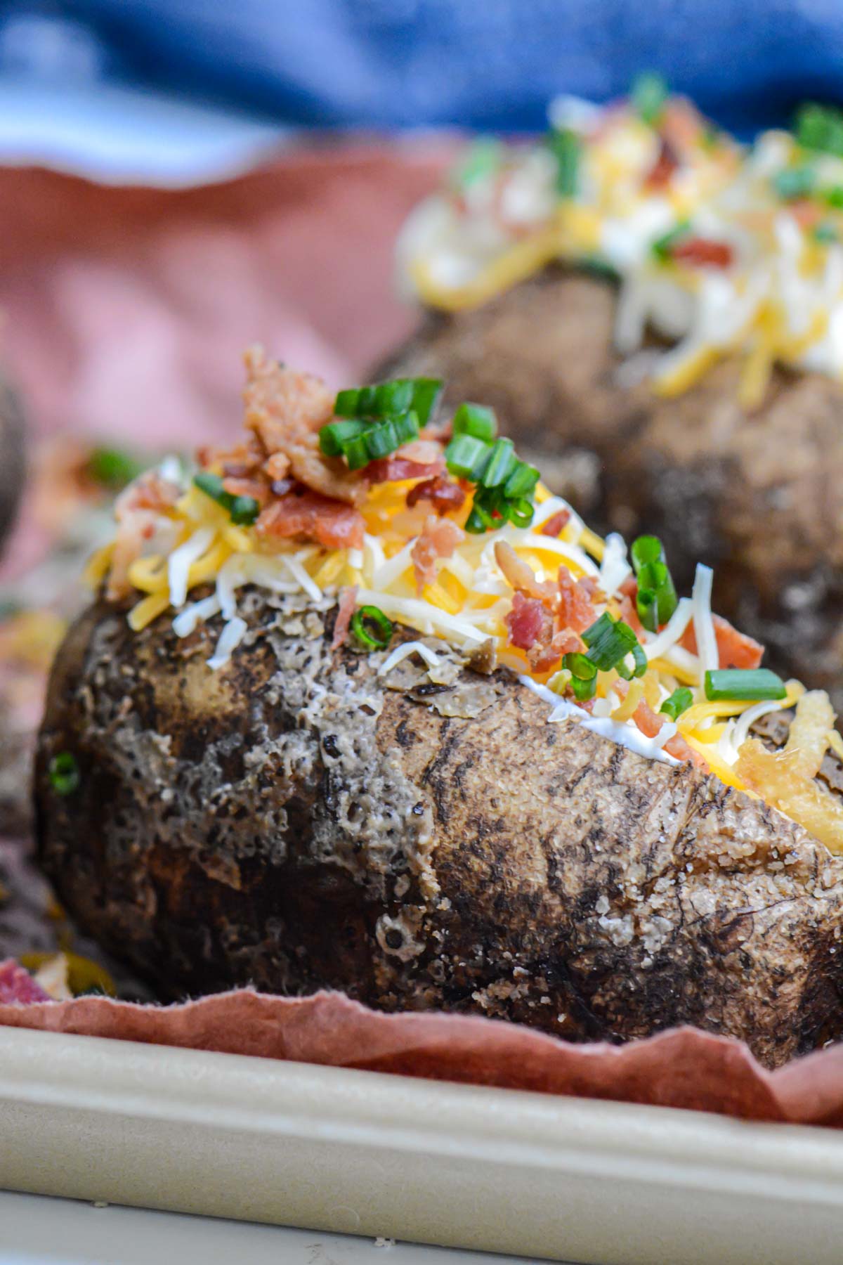 fully loaded salt crusted smoked baked potato topped with chives, cheese, bacon and sour cream.
