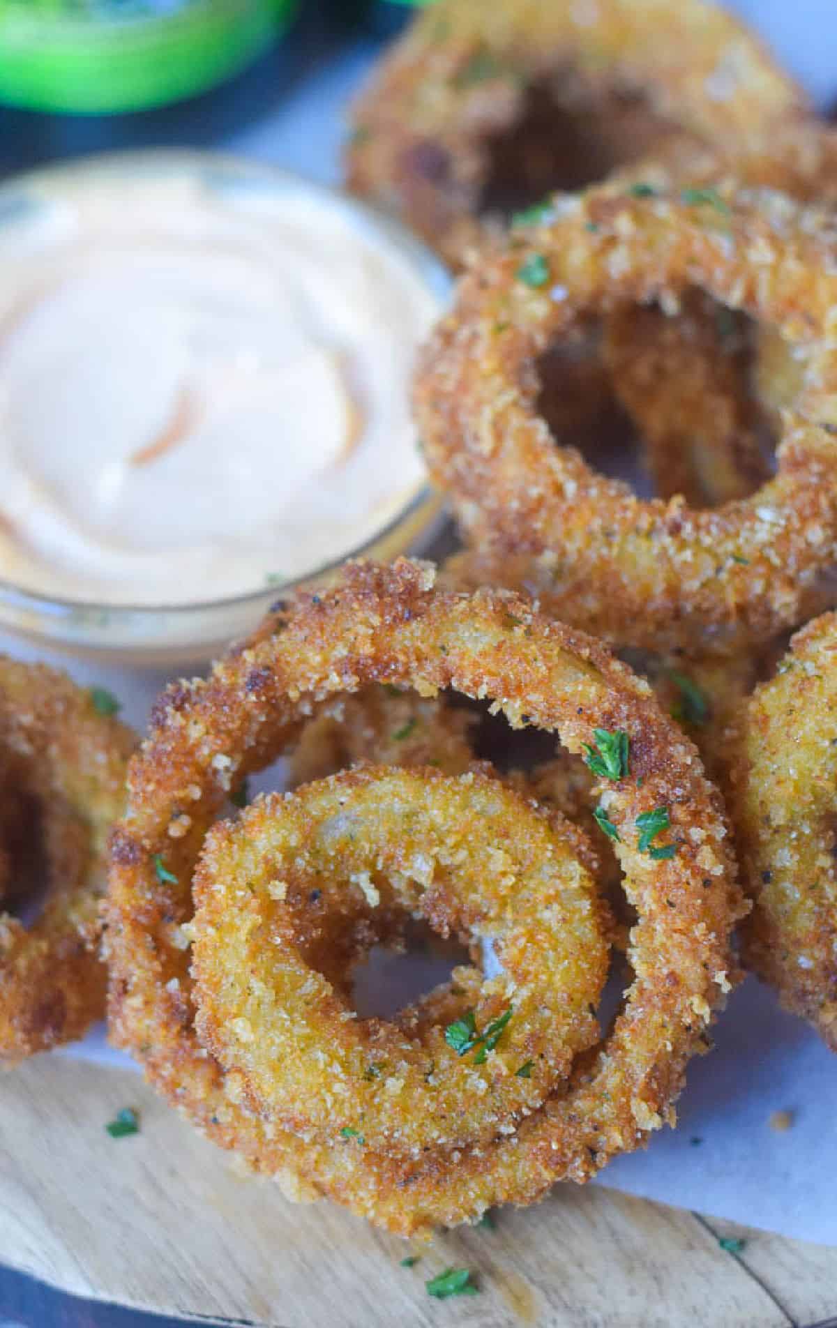 parmesan onion rings on a serving tray with a fun dip.