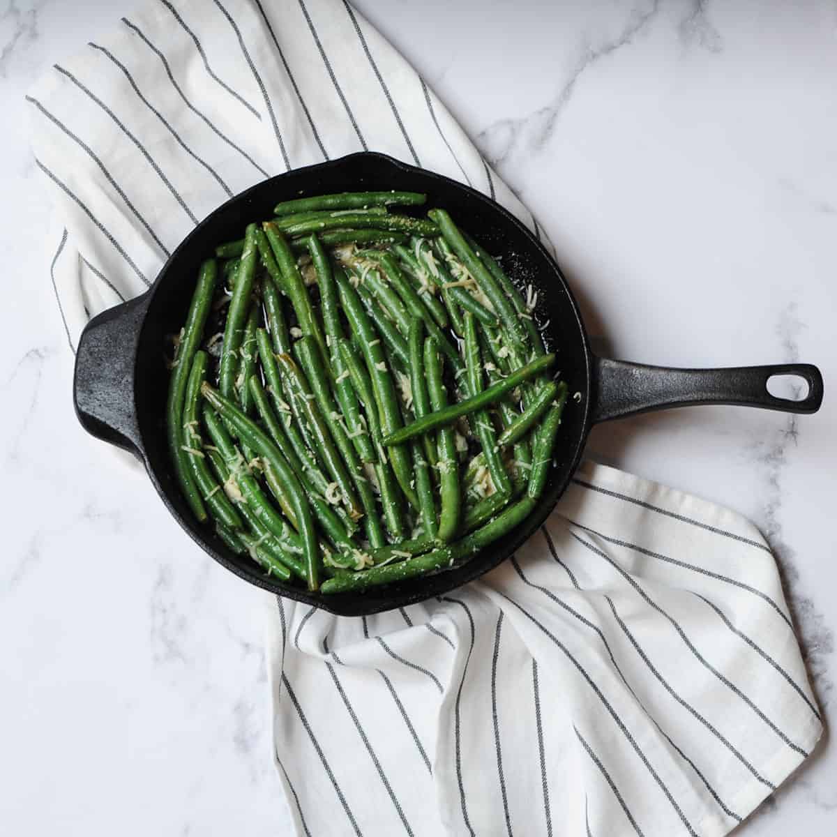 top down view of green beans in a cast iron skillet.