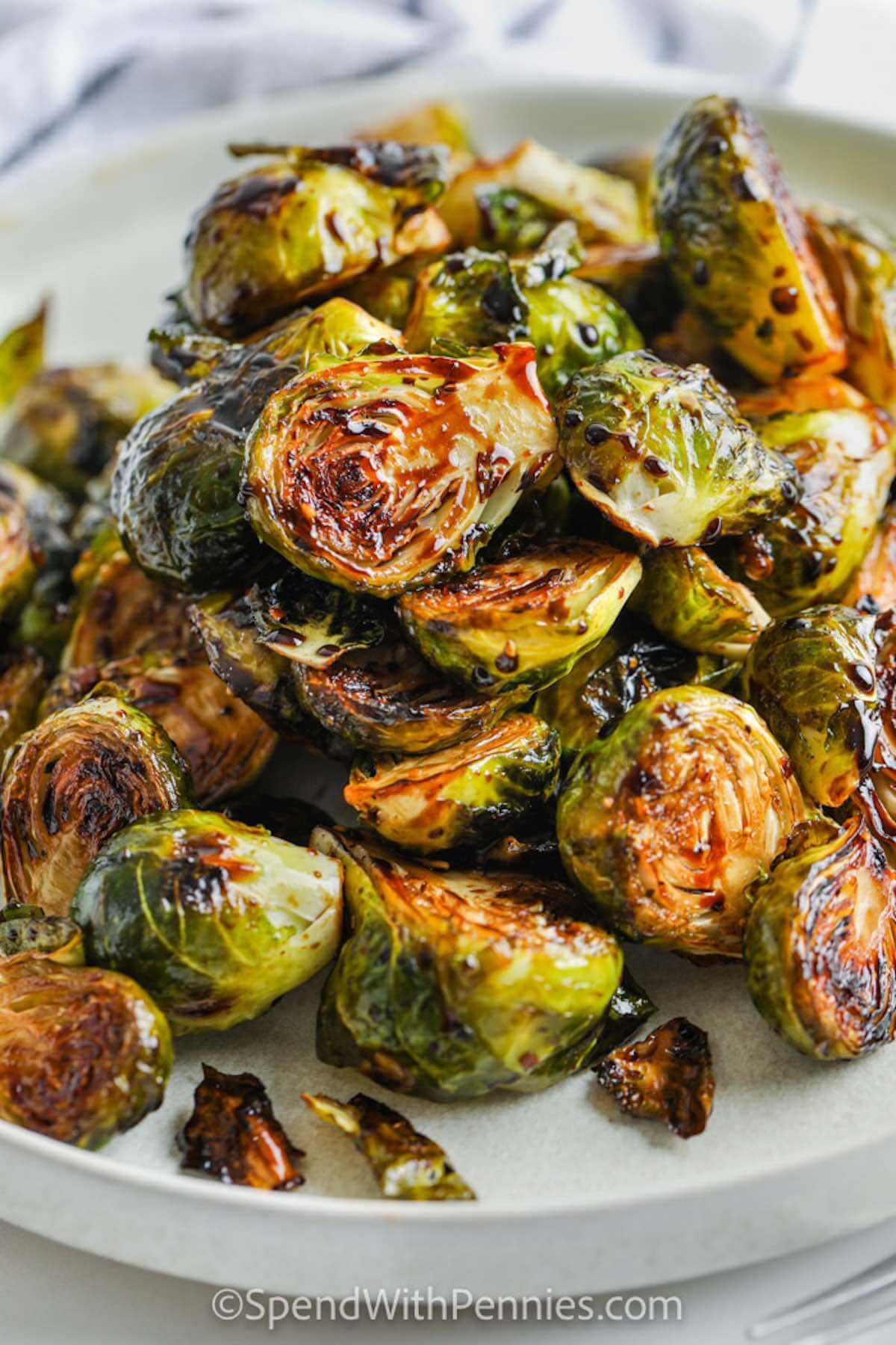 Brussel sprouts with a caramelized layer on a white plate.  