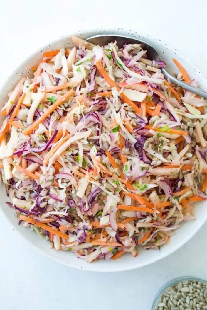 a classic coleslaw mixed in a white bowl. 