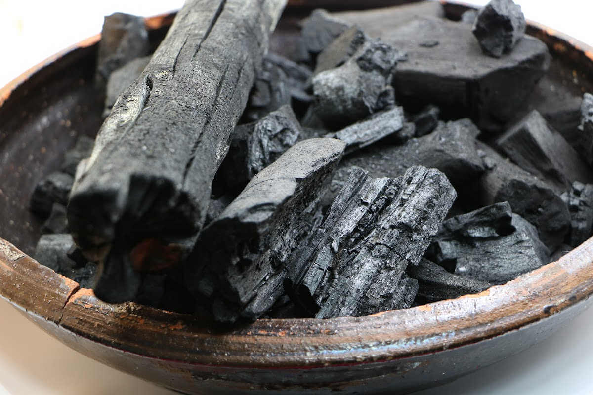 ceramic bowl filled with natural hardwood lump charcoal.