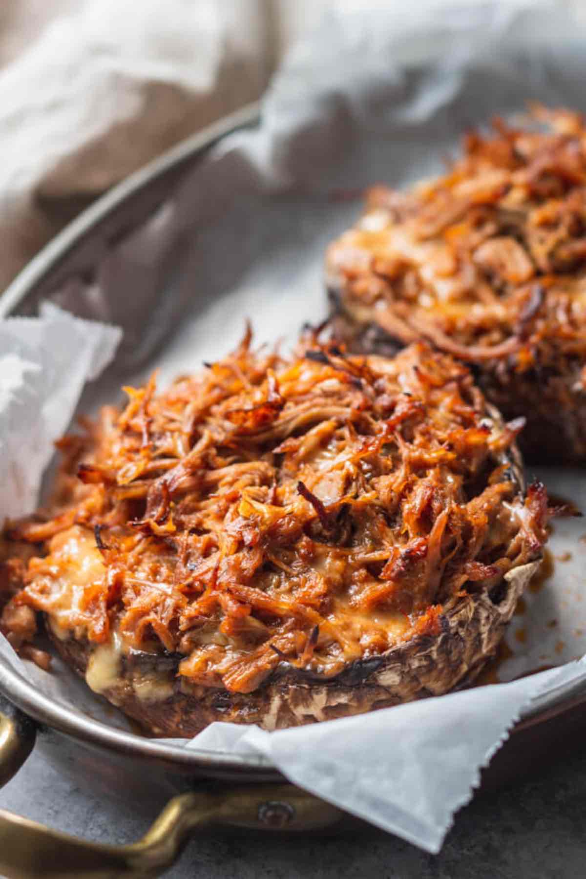 portobello mushroom filled with pulled pork in a pan.