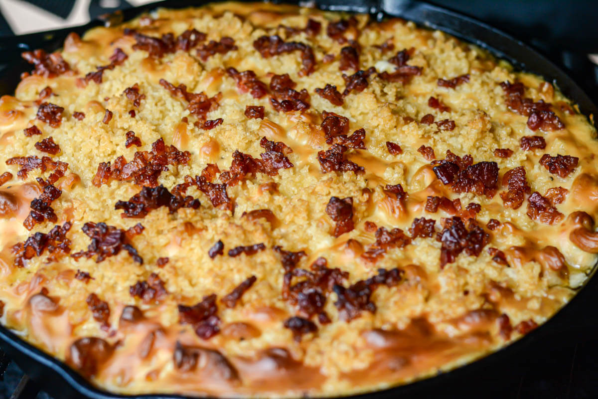 cast iron skillet with smoked mac and cheese topped with bacon bits.