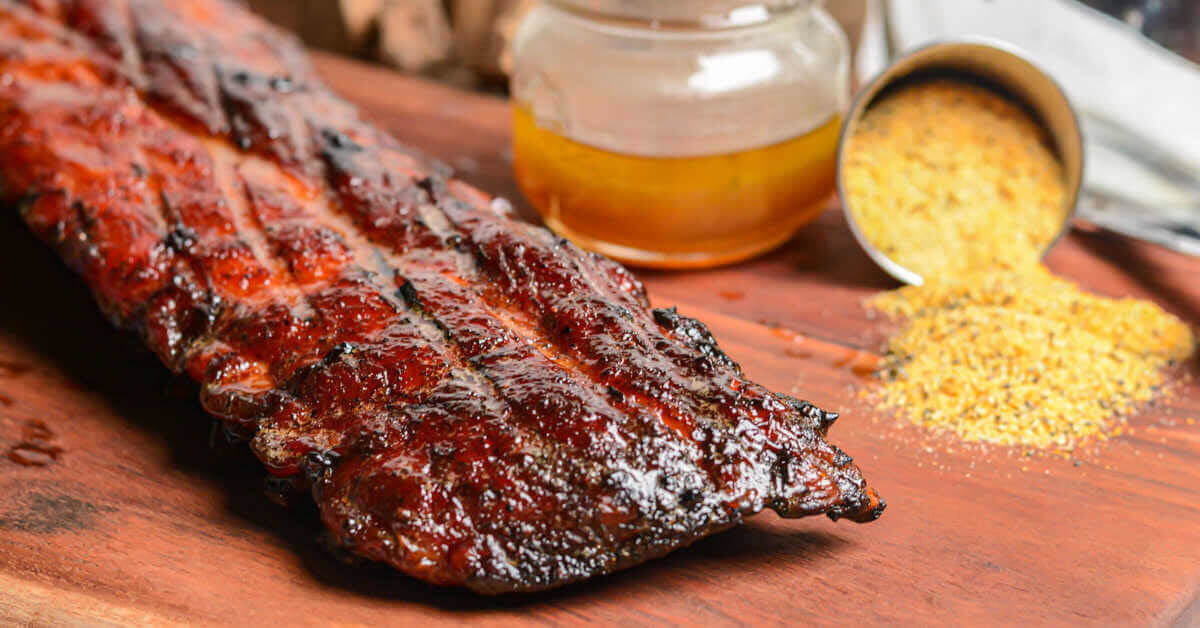 Smoked baby back ribs on wooden table.