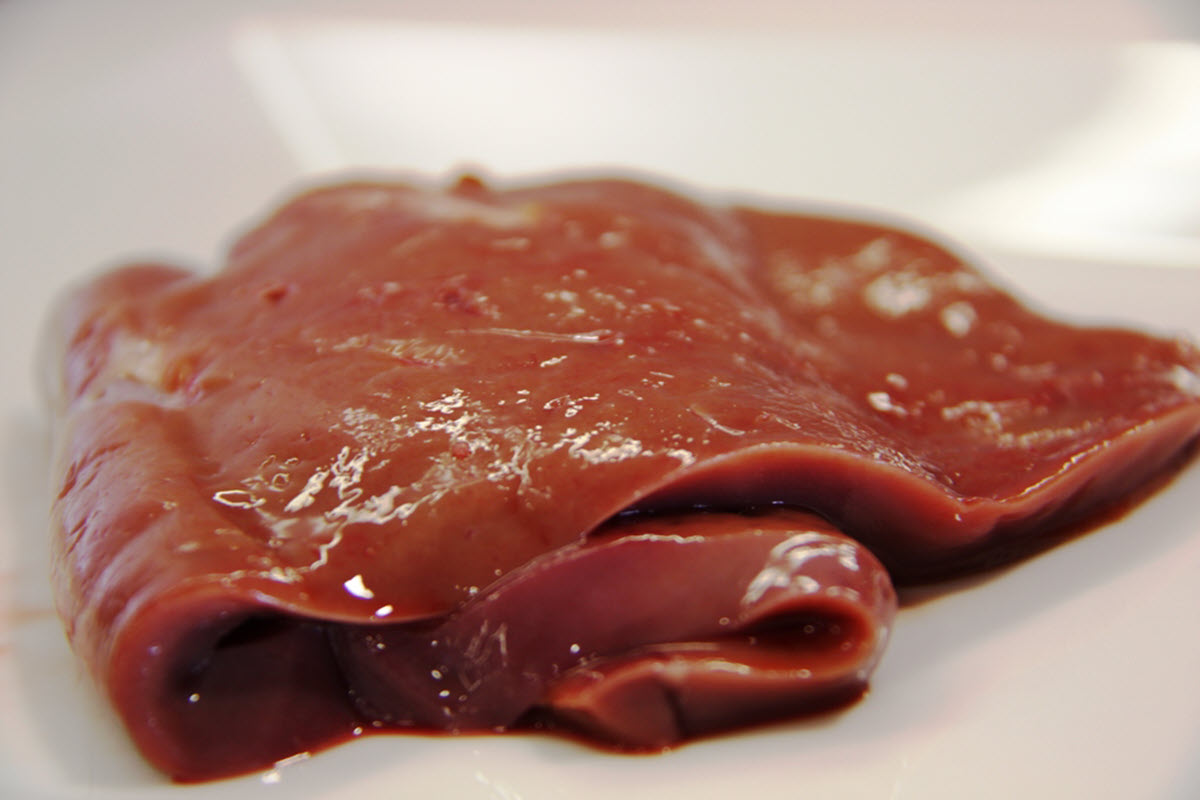 Raw beef liver on white background.