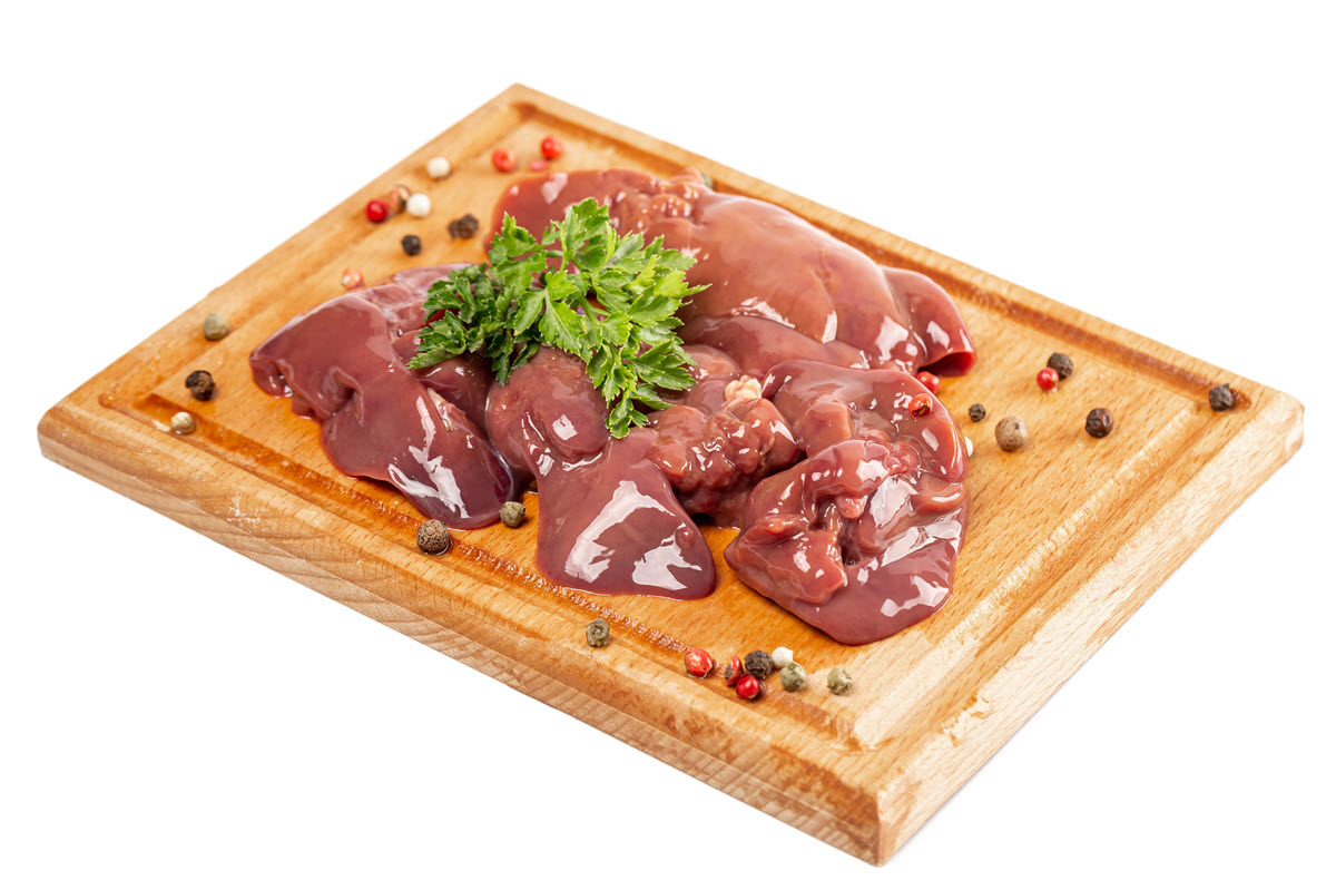 Raw chicken liver with spices on wooden cutting board. 