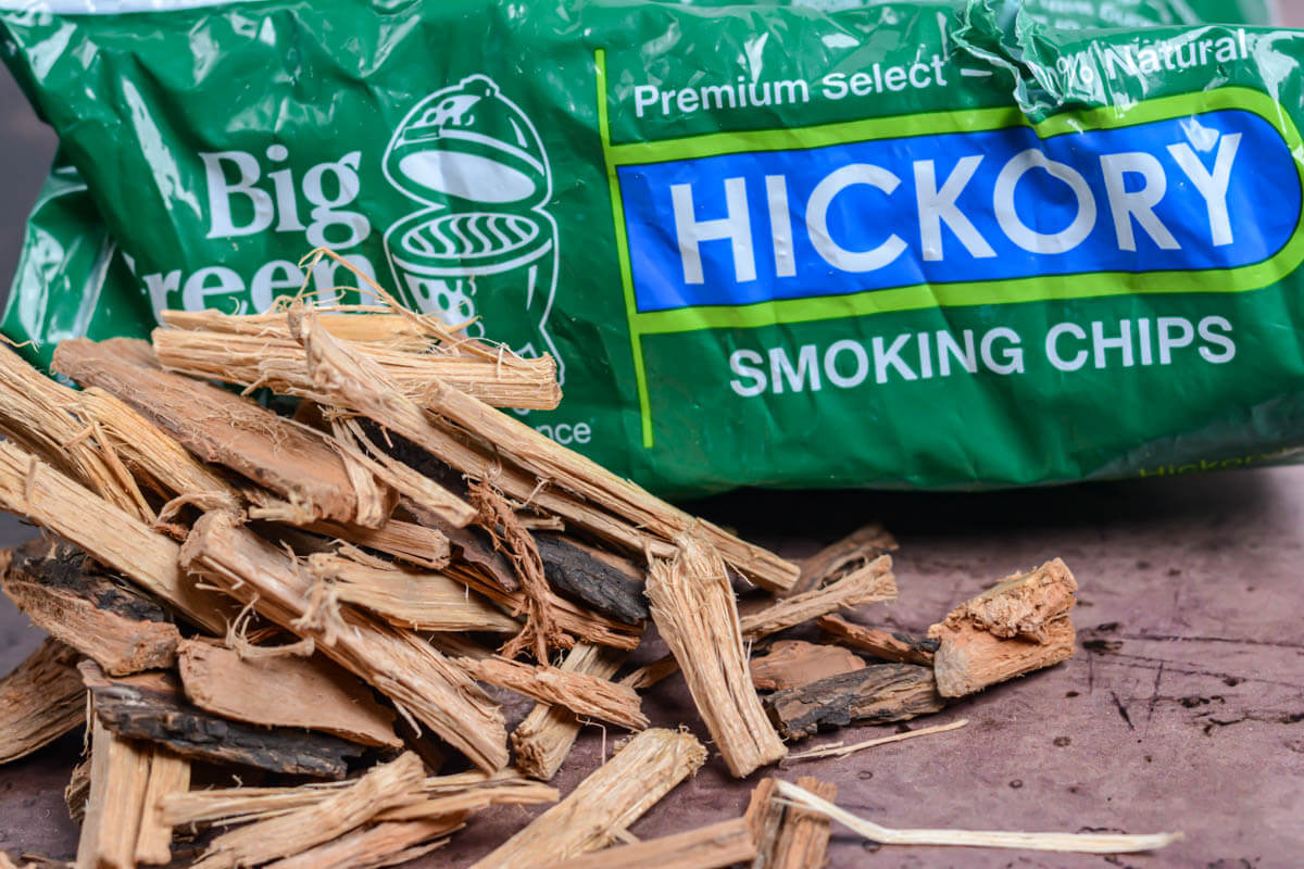 shredded hickory smoking chips with the big green egg bag in the background.