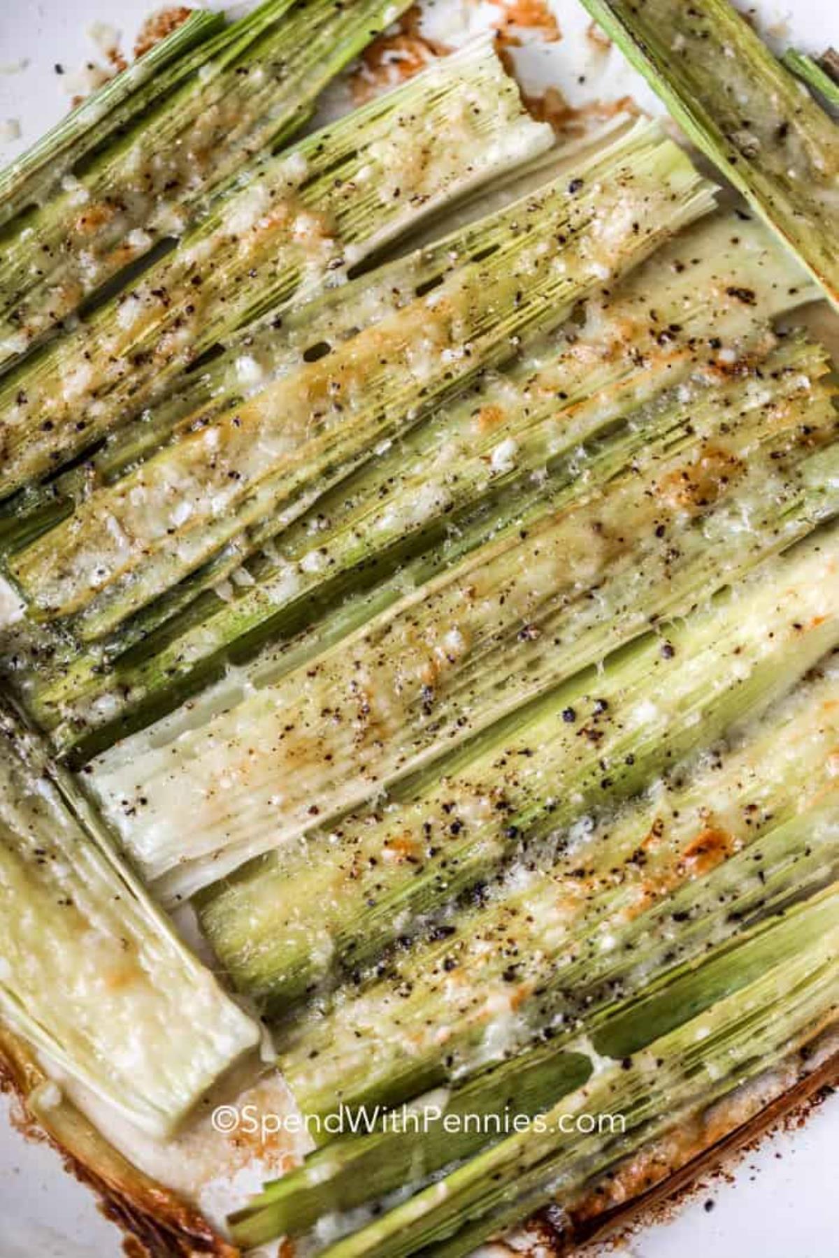 Top view of roasted leeks topped with Parmesan cheese.