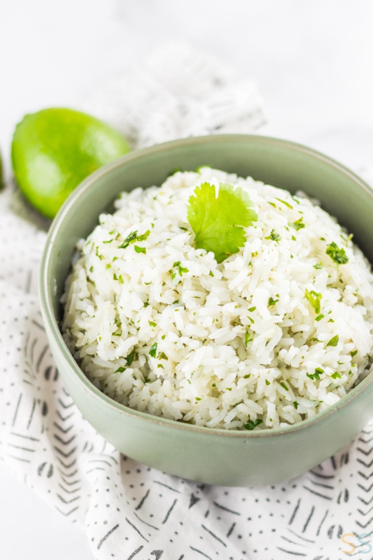 Cilantro lime rice in bowl next to fresh lime.
